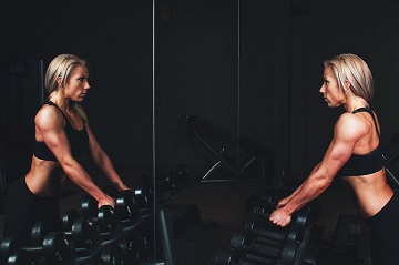 fit woman with dumbbells in the gym